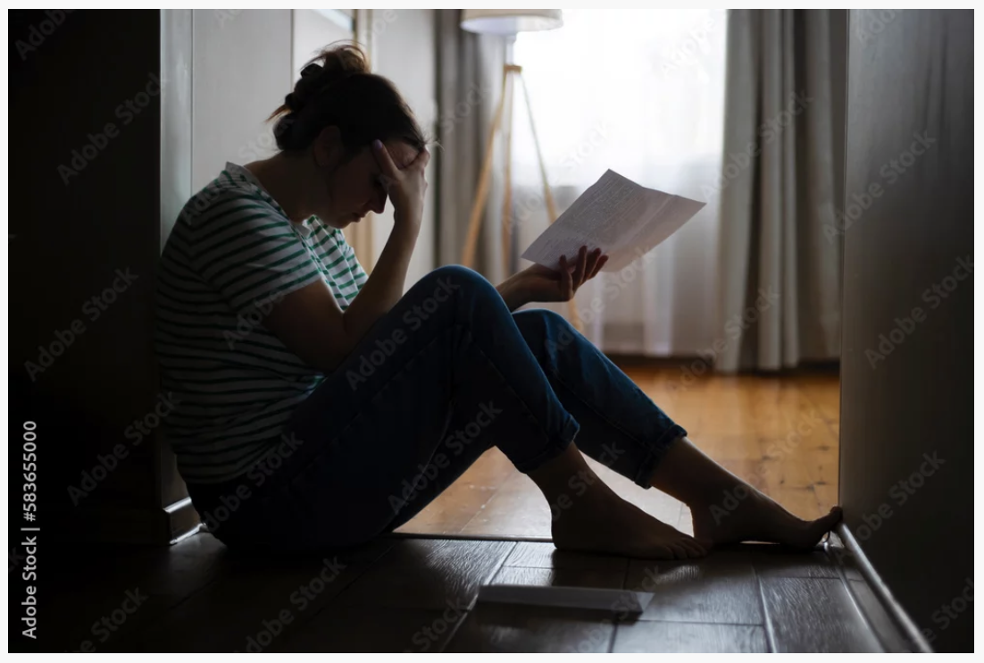 Stressed California tenant reviewing eviction paperwork
